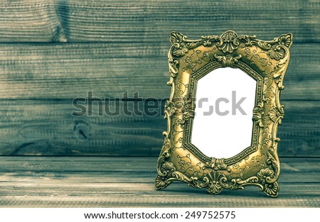 Golden baroque style frame on wooden background with place for your picture