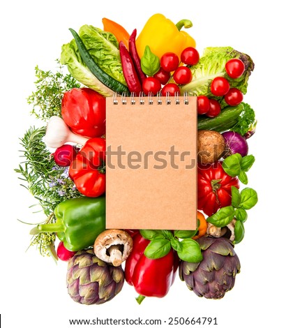 recipe book with fresh organic vegetables and herbs isolated on white background. healthy food ingredients