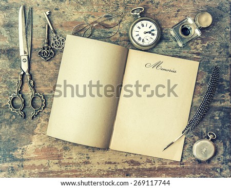 Paper page and vintage writing tools. Feather pen, inkwell, keys on textured wooden background. Memories. Retro style toned picture
