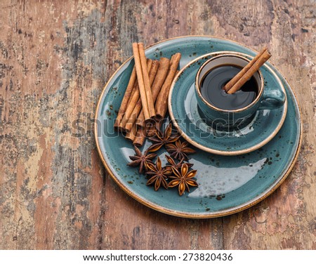 Cup of black coffee with cinnamon and star anise spices. Vintage style still life