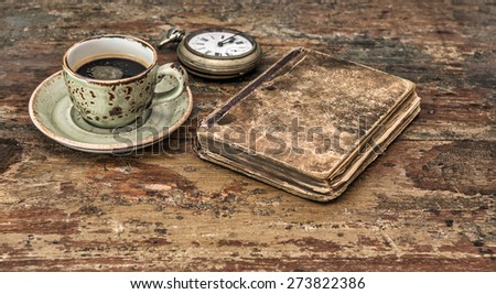 Cup of black coffee and antique book. Retro still life. Vintage style toned picture