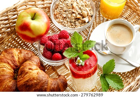 Breakfast with coffee, croissants, orange juice and fresh strawberry yogurt