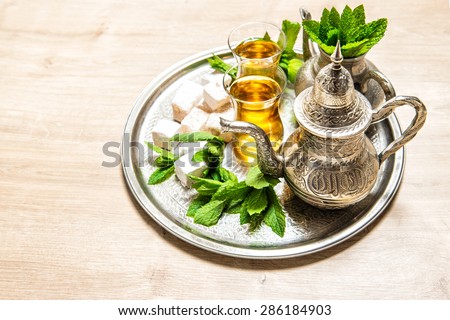 Tea with mint leaves and traditional turkish delight. Oriental hospitality concept. Holidays table setting. Ramadan kareem