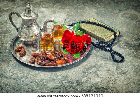 Tea and red rose flower, holy book quran and rosary. Islamic holidays decoration. Ramadan kareem. Eid mubarak. Oriental hospitality concept. Vintage style toned picture