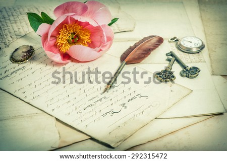 Old handwritings, antique feather pen, keys, pocket watch and pink peony flower. Sentimental vintage background. Retro style toned picture