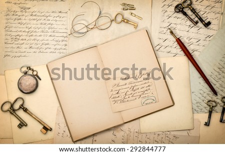 Open book, vintage accessories, old letters and postcards. Nostalgic paper background