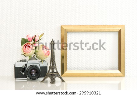Golden picture frame, rose flowers and no name vintage camera. Retro style decoration with space for your photo or text. Paris travel concept