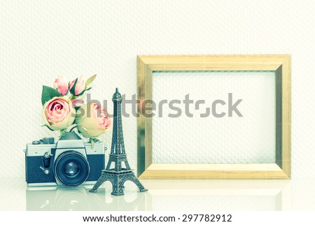 Golden picture frame, rose flowers and no name vintage camera. Retro style decoration with Eiffel Tower from Paris souvenir. Cross processing toned