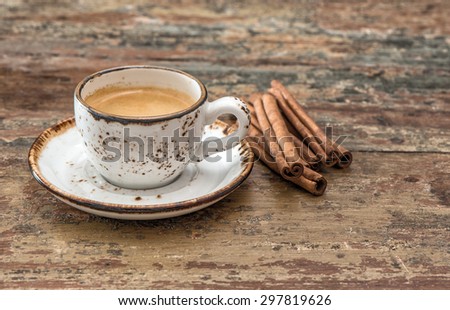 Cup of black coffee with cinnamon spices. Vintage style still life. Creative food
