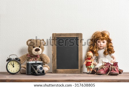 Doll, Teddy Bear, chalkboard and vintage toys. Retro style still life. No name toys
