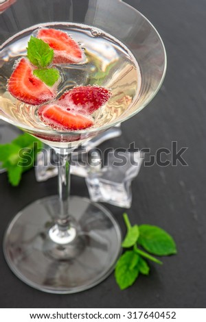Strawberry cocktail with berry in martini glass isolated on white background. Sparkling wine and fresh fruits