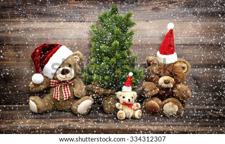 Christmas decoration with funny toys Teddy Bear family. Vintage style toned picture with falling snow effect