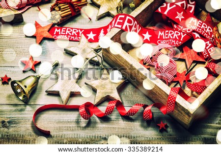 Christmas decoration and ornaments on rustic wooden background. Retro style dark colored picture with light effects