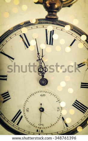 Five to twelve. Clock face and party lights decoration. Vintage style toned picture