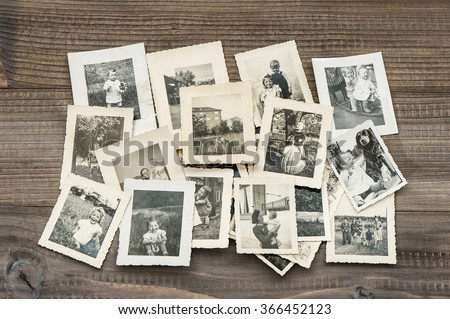 Old family photos on wooden table. Vintage pictures