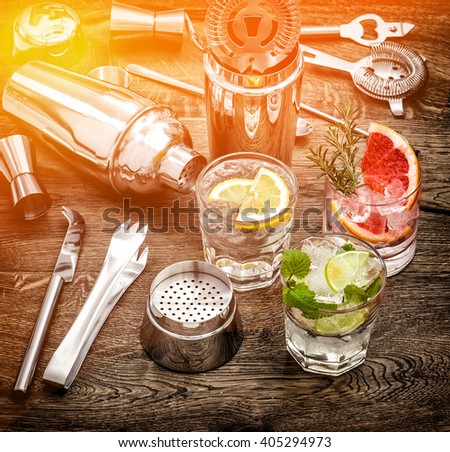 Drinks with ice and tonic water. Cocktail accessories. Vintage style toned picture with color lights effect