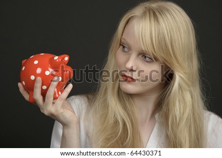 Blond woman with red piggy savings box