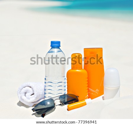 water and sun protection cream on beach background