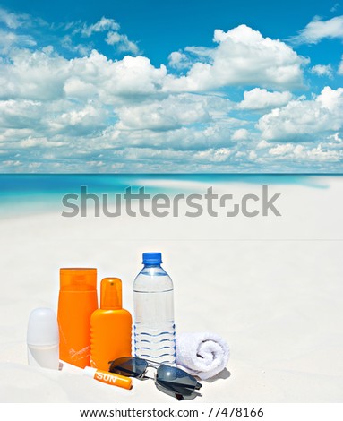 sun protection cream on beach background. blue cloudy sky