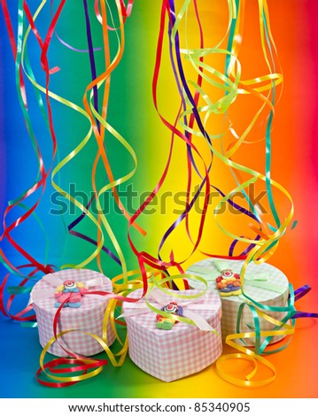 Colorful party or holiday decoration. gifts on rainbow background with streamer