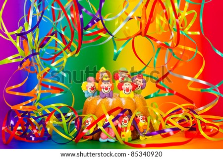 Birthday cake with clown decoration and rainbow background. Party streamer