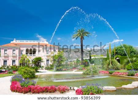 mediterranean garden with fountain, colorful flowers and blue sky. Near Nice, Cote d\'Azur, France