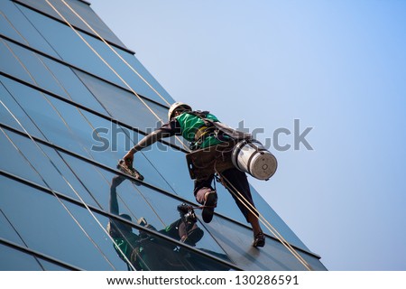 Group Of Workers Cleaning Windows Service On High Rise Building
