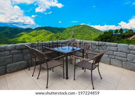 cafe table and chairs with mountain view and blue sky