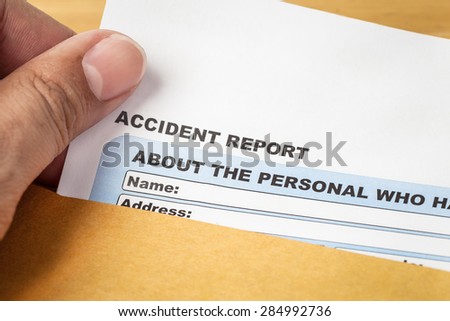 Accident report application form and human hand on brown envelope, business insurance and risk concept; document is mock-up