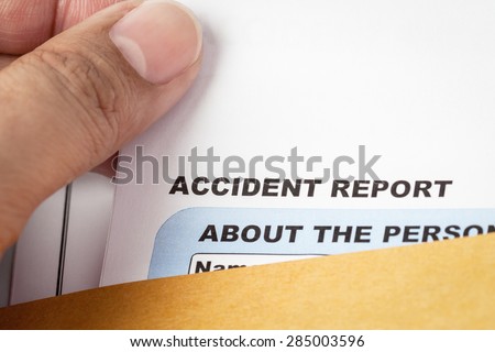 Accident report application form and pen on brown envelope and eyeglass, business insurance and risk concept; document is mock-up