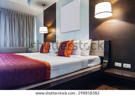 BANGKOK THAILAND - JUNE 18 : Red pillow on double bedroom with white bed sheet and lamp light on, in Spring Field at Sea hotel in Cha-am Phetchaburi, Thailand on June 18, 2015