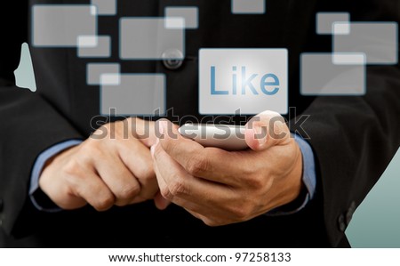 Businessman touch smart phone in hand with like button social network