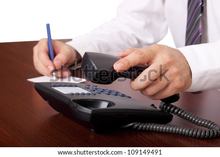 man is answering or hanging up the phone in an office