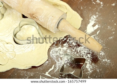 flat dough with metallic shapes and rolling pin