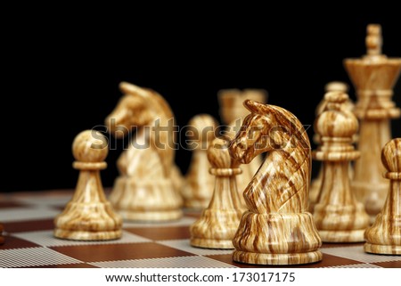 selective focus on chess horse on black background