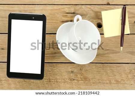tablet pc, cup and notes levitating above wooden desk