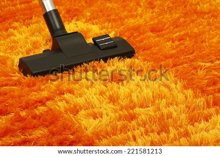 vacuum cleaner on orange fluffy carpet closeup