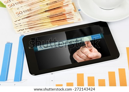 tablet computer with graphs and banknotes, making money online concept