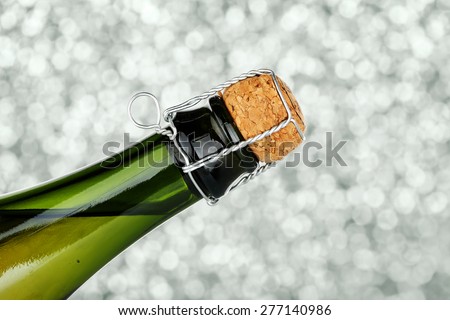 closeup of champagne bottle with cork against abstract background