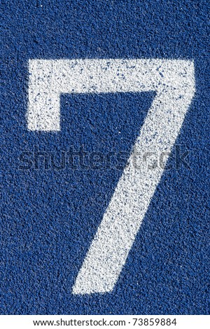 Starting number seven on a blue tartan athletic running track on the stadium. Tartan track is the trademarked all-weather synthetic track surfacing for athletics made of polyurethane