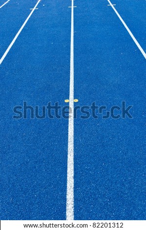 Blue tartan athletic running track texture on the stadium. Tartan track material is the trademarked all-weather synthetic track surfacing for athletics made of polyurethane