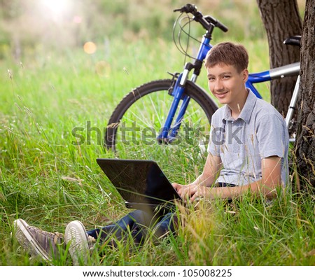 Boy in park with laptop