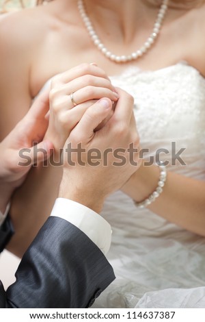 The groom holds the bride\'s hand