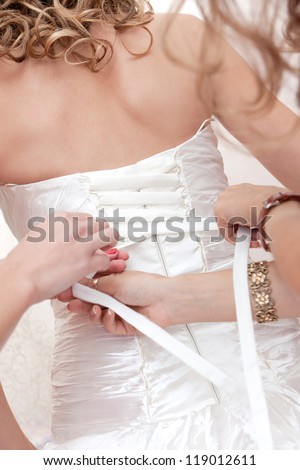 Tying ribbons on wedding dress