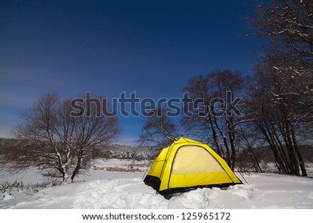 Tourist tent in the snow, on the starry sky.