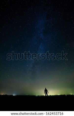 The man on the background of bright stars of the night sky. The Milky Way.
