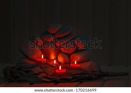 Candles are lit on the background of the sauna stones. Preparing for the ceremony bathhouse