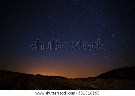 The starry sky and Milky Way  above the lighted lanterns city.