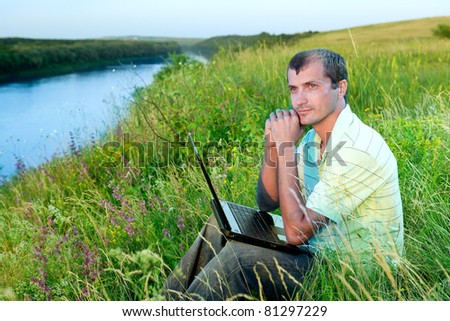The man with the laptop on river bank
