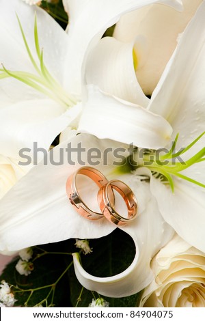 stock photo Wedding gold rings lie on a bunch of flowers for the bride